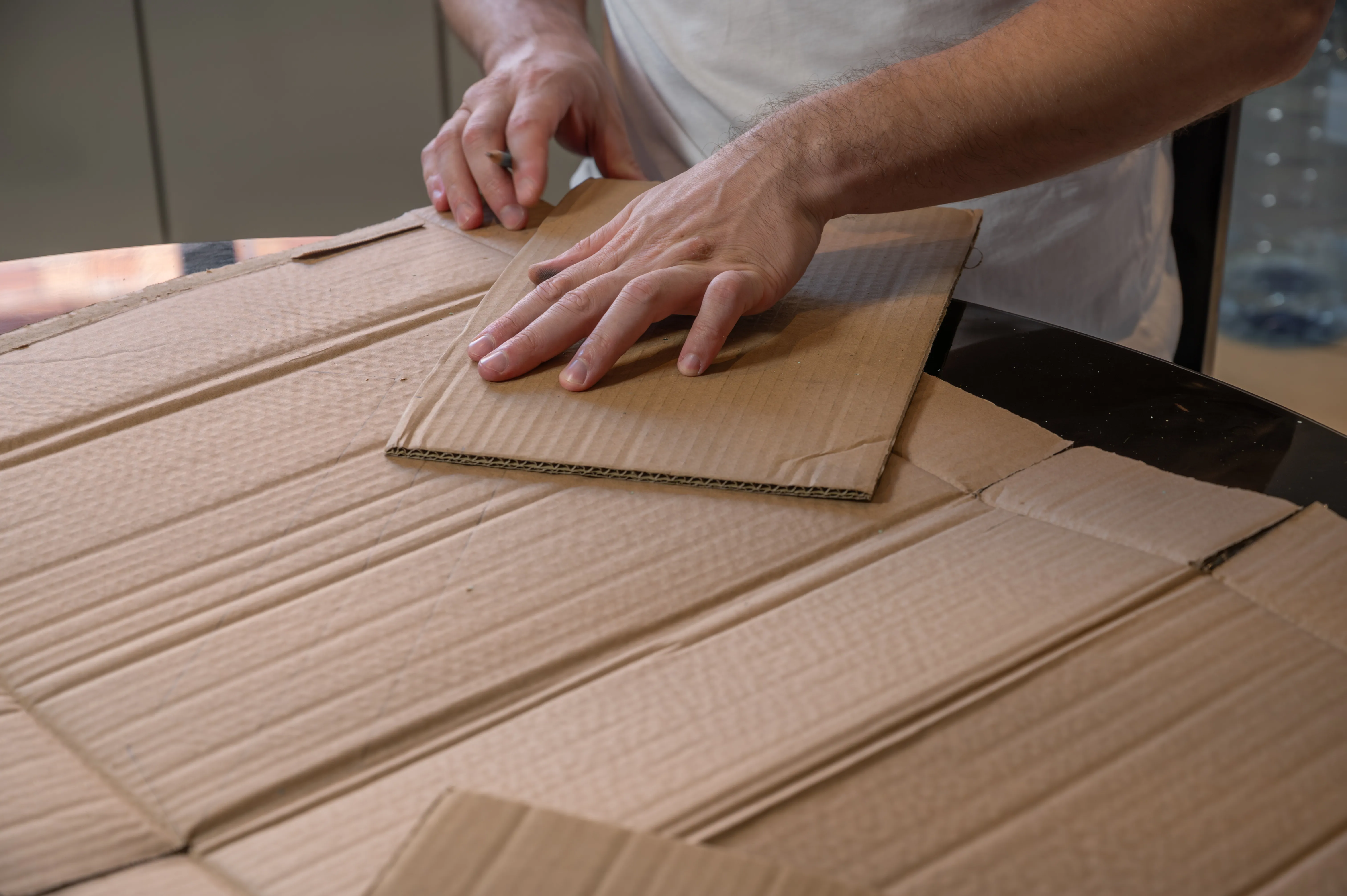 Hands preparing cardboard packaging for shipment